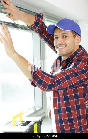 man is installing window blinds Stock Photo