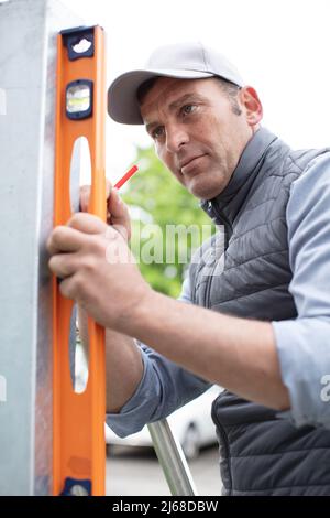man measures the level outdoors Stock Photo