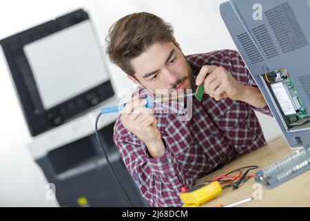 a technician soldering printer cables Stock Photo