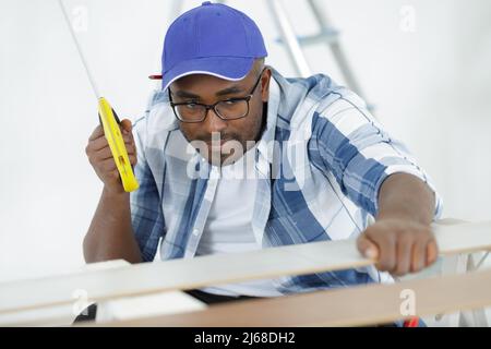 a man carpenter cuts a wooden beam using a handsaw Stock Photo