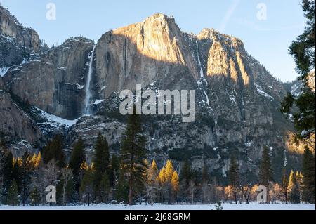 Yosemite falls during golden hour on a snow-covered winter afternoon.