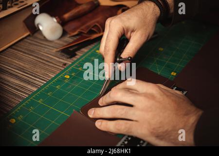 leatherworker embossing. Tanner works with leather Stock Photo