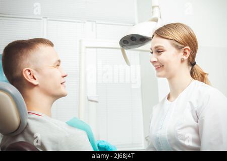 European female dentist doctor treats patient, portrait. Professional service, friendly, smiling, happy and satisfied, calm. Stock Photo
