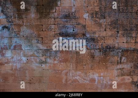 Old red brick wall with faded paint and cracks in Bali, Indonesia. Stock Photo