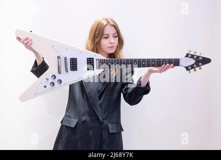 Bonhams, Knightsbridge, London, UK. 29 April 2022. Rock, Pop and Film Online sale includes the Gary Moore guitar Collection Part III, ending 4 May. Image: Bonhams staff member holds the Gary Moore: Gibson Flying V Guitar, 2007, estimate £6,000-8,000. Credit: Malcolm Park/Alamy Live News. Stock Photo