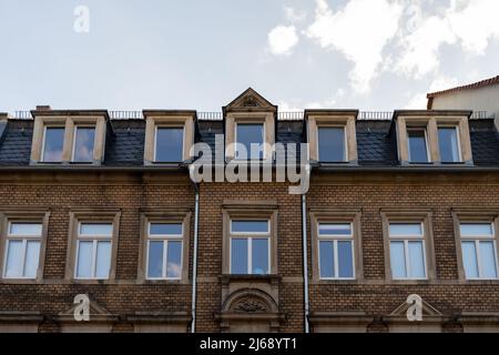 House facade with old yellow clinker bricks in a German city. Front view off a weathered dirty residential building. Old architecture in Germany. Stock Photo