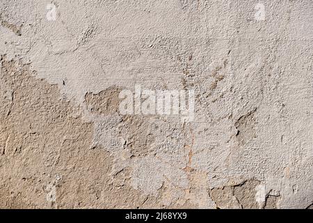 Weathered wall plaster with cracks and imperfections background. Full frame texture of white render. Material surface pattern with dirt and damage. Stock Photo