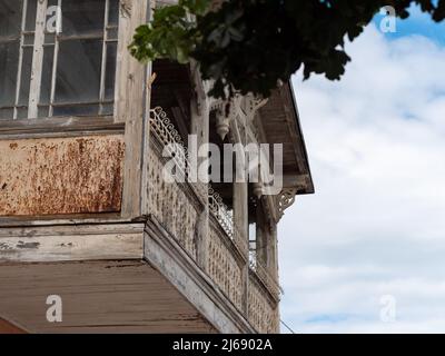 An old abandoned balcony out of timber and glass. White wooden part of a building on a sunny summer day. Historical architecture in a German city. Stock Photo
