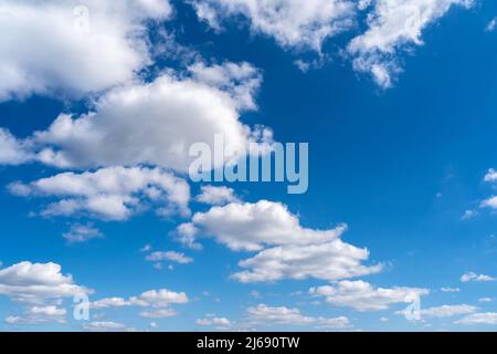 Blue sky with beautiful white soft clouds. Full frame background on a sunny day. Cloudscape in the nature heaven. Abstract photo of summer weather. Stock Photo
