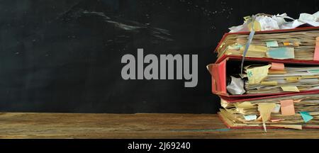 Stack of messy file folders,red tape,close up, bureaucracy,aministration,business concept. Free copy space,negative space technique. Stock Photo