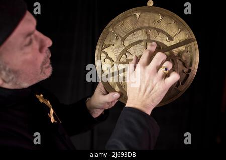 Replica of an astrolabe (or fusoris) being used by a 15th Century astronomer to calculate the position of the Sun and prominent stars. Stock Photo