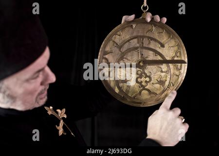 Replica of an astrolabe (or fusoris) being used by a 15th Century astronomer to calculate the position of the Sun and prominent stars. Stock Photo