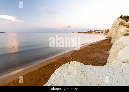 Calm sea at dawn framed by limestone cliffs overlooking the gold sand of Xi beach, Kefalonia, Ionian Islands, Greek Islands, Greece, Europe Stock Photo