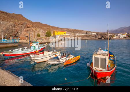 View of colourful boats in harbour and mountains in background, Puerto de La Aldea, Gran Canaria, Canary Islands, Spain, Atlantic, Europe Stock Photo