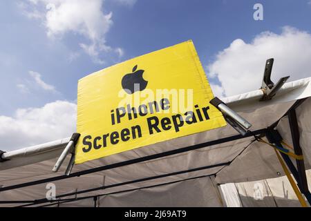 Apple iPhone screen repair sign at a mobile phone repair stall, Suffolk UK Stock Photo