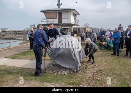 Newhaven, UK. 28th Apr, 2022. 100 people gathered at the end of Newhaven Harbour for the unveiling of a memorial to remember fishermen lost at sea.  The sculpture, a copper-clad shoal of fish, was dedicated to six men who have lost their lives off the coast of Newhaven.  The statue is  meant to be a dynamic ball of fish, like a bait ball which fish form when being chased by dolphins.   The memorial is at the bottom of Fort Road in Newhaven   Robert Morley's family have been campaigning for a permanent memorial for those who have died fishing off the sussex coast in recent years, raising more t Stock Photo