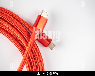 close up of a bright red USB type C to USB C cable isolated on a white background Stock Photo