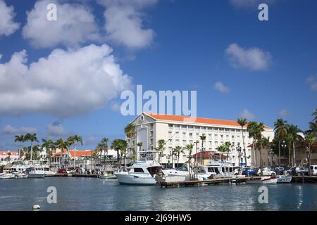 ORANJESTAD, ARUBA - DECEMBER 16, 2020: Fishing boats in Wind Creek Marina and the Renaissance Hotel in the back in Oranjestad, Aruba Stock Photo