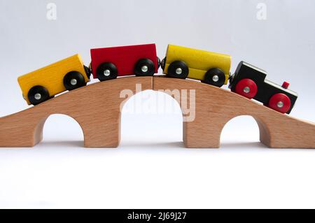 Wooden toy train crossing track bridge. Conceptual Stock Photo
