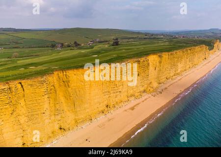 West Bay, Dorset, UK.  29th April 2022.  UK Weather.  General view from the air of the beach and sandstone cliffs at the seaside resort of West Bay in Dorset which is bathed is hot sunshine ahead of the bank holiday weekend.  Picture Credit: Graham Hunt/Alamy Live News Stock Photo