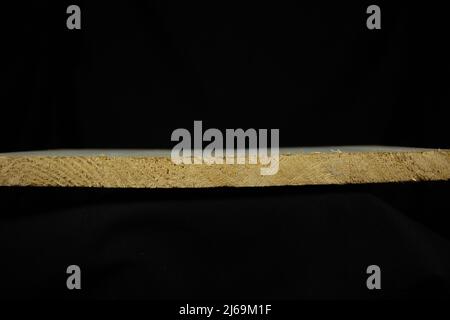 end view of a cut piece of soft pine isolated on a black background Stock Photo