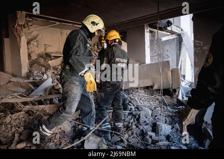 Kyiv, Ukraine. 29th Apr, 2022. April 29, 2022, Kiev, Kyiv, Kiev, Kyiv, Ukraine: Rescuers seen walking through debris. While rescuers search for people, workers clean the area and  after missile hit a building in Schevchenko district in Kyiv (Kiev), on April 28th. Nearly dozen of people were injured and Radio Liberty journalist, Vera Gyrych, died. (Credit Image: © Valeria Ferraro/ZUMA Press Wire) Credit: ZUMA Press, Inc./Alamy Live News Stock Photo