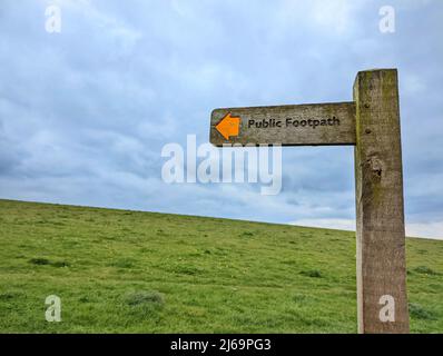 Public footpath signpost on a meadow hill. High-quality photo Stock Photo