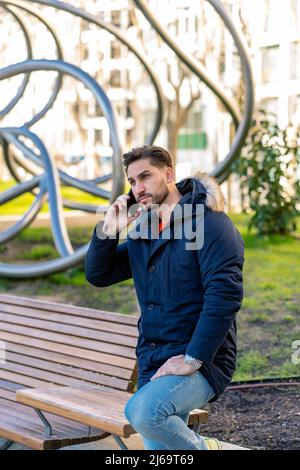 elegant young man talking on his smartphone Stock Photo