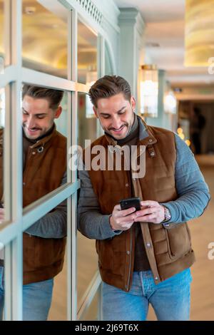 elegant young man using his smartphone Stock Photo