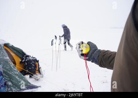 Big beautiful yellow compass in hand. A traveler holds a gloved compass at the north pole in winter. Compass on a winter expedition Stock Photo