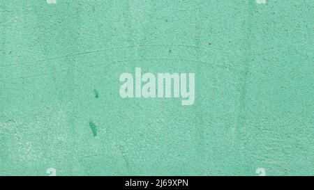 Green painted concrete surface. Texture of old wall covered with green stucco. Grunge color painted background Stock Photo