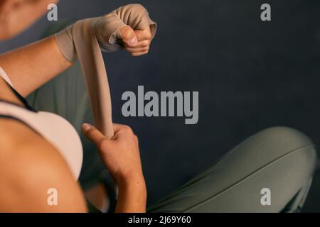High angle shot of unrecognizable woman wrapping her hands with elastic bandage Stock Photo