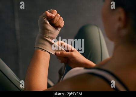 From above horizontal shot of professional female boxing using wristwraps for protecting her hands Stock Photo