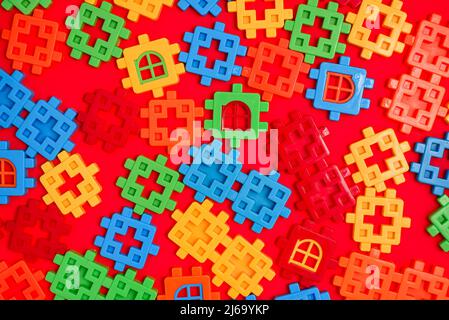 Bright background texture from multi-colored plastic fragments of a childrens puzzle constructor Stock Photo