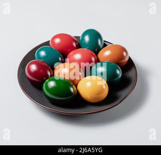 Ceramic plate with multicolor easter eggs on white background, stock photo Stock Photo
