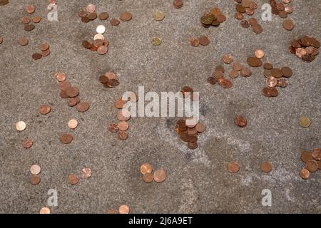 Coins of different countries of the world are left on stone to be returned back. Small denomination coins. Stock Photo