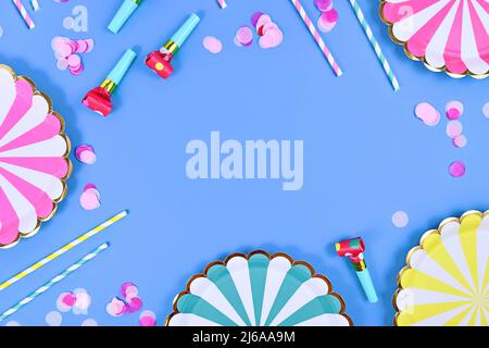 Party flat lay with paper plates, drinking straws and confetti on blue background with copy space Stock Photo