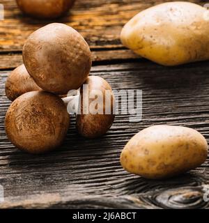 Fresh mushrooms, champignon, potato, wooden background, selective focus, stock photo Stock Photo