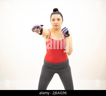 beautiful athletic asian woman in gray sportswear red top, practicing boxing, punches to the front, white background Stock Photo