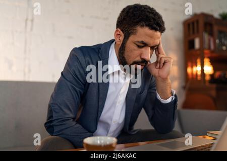 Busy young businessman with headache when doing his work. Stock Photo