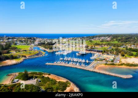 Bermagui town harbour on Bermagui river entering Pacific ocean on Sapphire coast of Australia - aerial townscape. Stock Photo