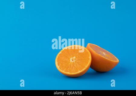 Two navel orange halves on solid blue background Stock Photo