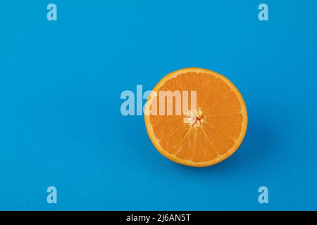 Halved navel orange on solid blue background Stock Photo