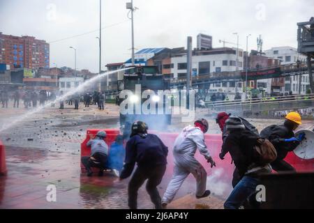 April 28, 2022, BogotÃ, Cundinamarca, Colombia: Protesters flee from water cannons and tear gas during the demonstration. Students clashed heavily with riot police at BogotÃ university as they marched to commemorate the day when the 2021 National Strike began in Colombia. (Credit Image: © Antonio Cascio/SOPA Images via ZUMA Press Wire) Stock Photo