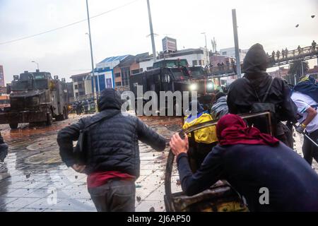 April 28, 2022, BogotÃ, Cundinamarca, Colombia: Protesters take cover from riot police during the demonstration. Students clashed heavily with riot police at BogotÃ university as they marched to commemorate the day when the 2021 National Strike began in Colombia. (Credit Image: © Antonio Cascio/SOPA Images via ZUMA Press Wire) Stock Photo