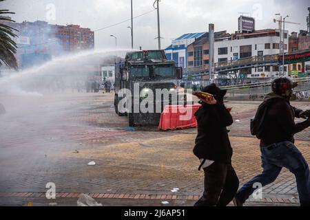 April 28, 2022, BogotÃ, Cundinamarca, Colombia: Protesters flee from water cannons during the demonstration. Students clashed heavily with riot police at BogotÃ university as they marched to commemorate the day when the 2021 National Strike began in Colombia. (Credit Image: © Antonio Cascio/SOPA Images via ZUMA Press Wire) Stock Photo