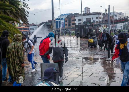 April 28, 2022, BogotÃ, Cundinamarca, Colombia: Protesters flee from water cannons during the demonstration. Students clashed heavily with riot police at BogotÃ university as they marched to commemorate the day when the 2021 National Strike began in Colombia. (Credit Image: © Antonio Cascio/SOPA Images via ZUMA Press Wire) Stock Photo