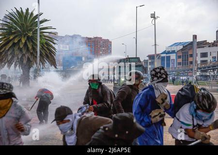 April 28, 2022, BogotÃ, Cundinamarca, Colombia: Protesters flee from water cannons during the demonstration. Students clashed heavily with riot police at BogotÃ university as they marched to commemorate the day when the 2021 National Strike began in Colombia. (Credit Image: © Antonio Cascio/SOPA Images via ZUMA Press Wire) Stock Photo