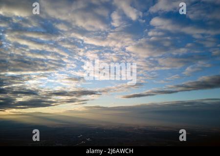 Aerial view at high altitude of dense puffy cumulus clouds forming before rainstorm in evening. Stock Photo