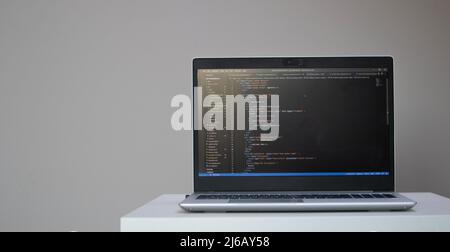 Banner of opened laptop with code on the screen on the table Stock Photo
